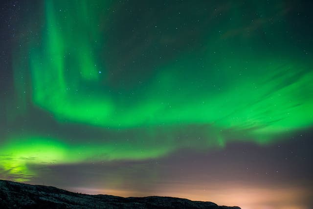 The Aurora Borealis or Northern Lights illuminate the night sky, near the town of Kirkenes in northern Norway