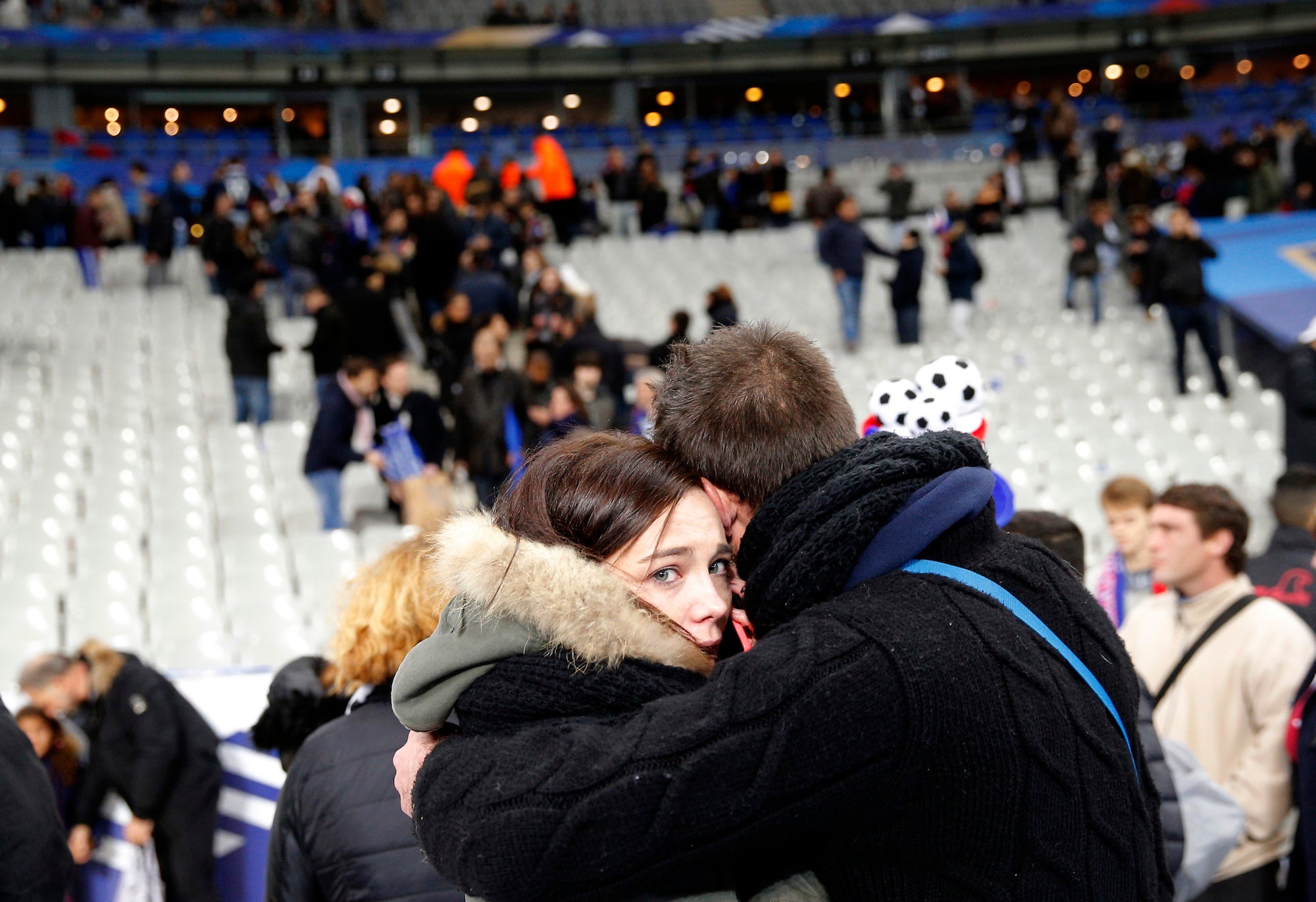 Friends embrace inside the Stade de France stadium in Paris.