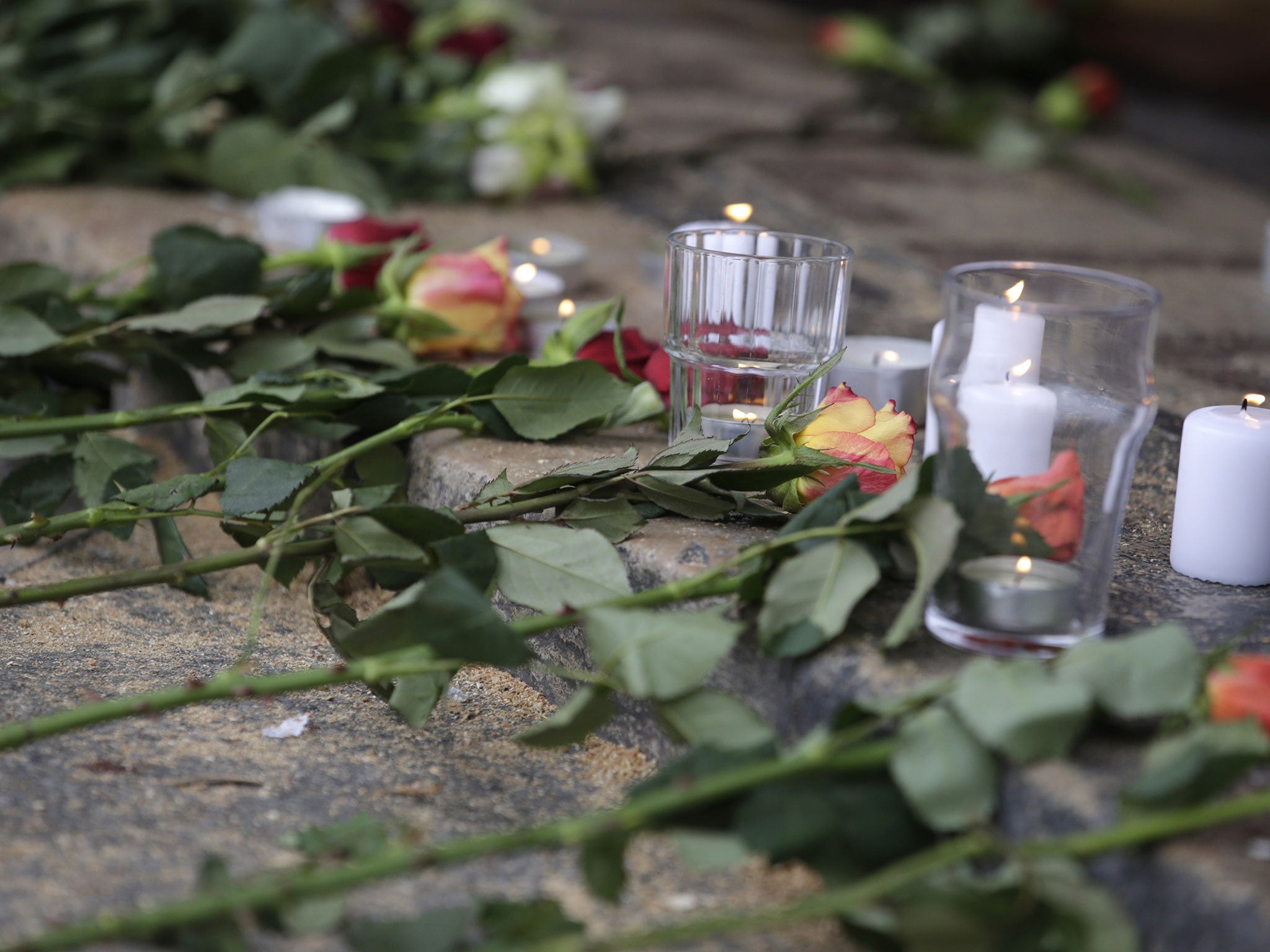 Flowers and candles are left outside the Carillon Bar in Paris