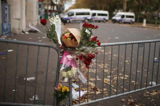 Flowers lie in front of a police cordon where concert-goers were killed at the Bataclan theatre in Paris