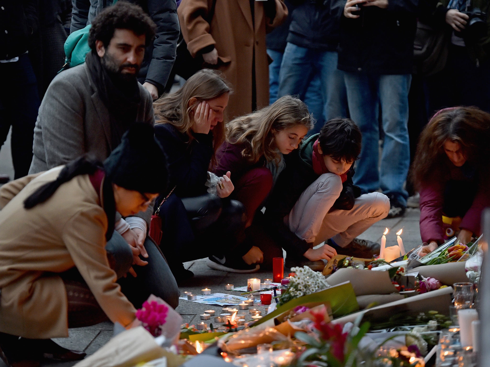 Mourners gather in front of the Petit Cambodge and Le Carillon restaurants on November 14, 2015 in Paris