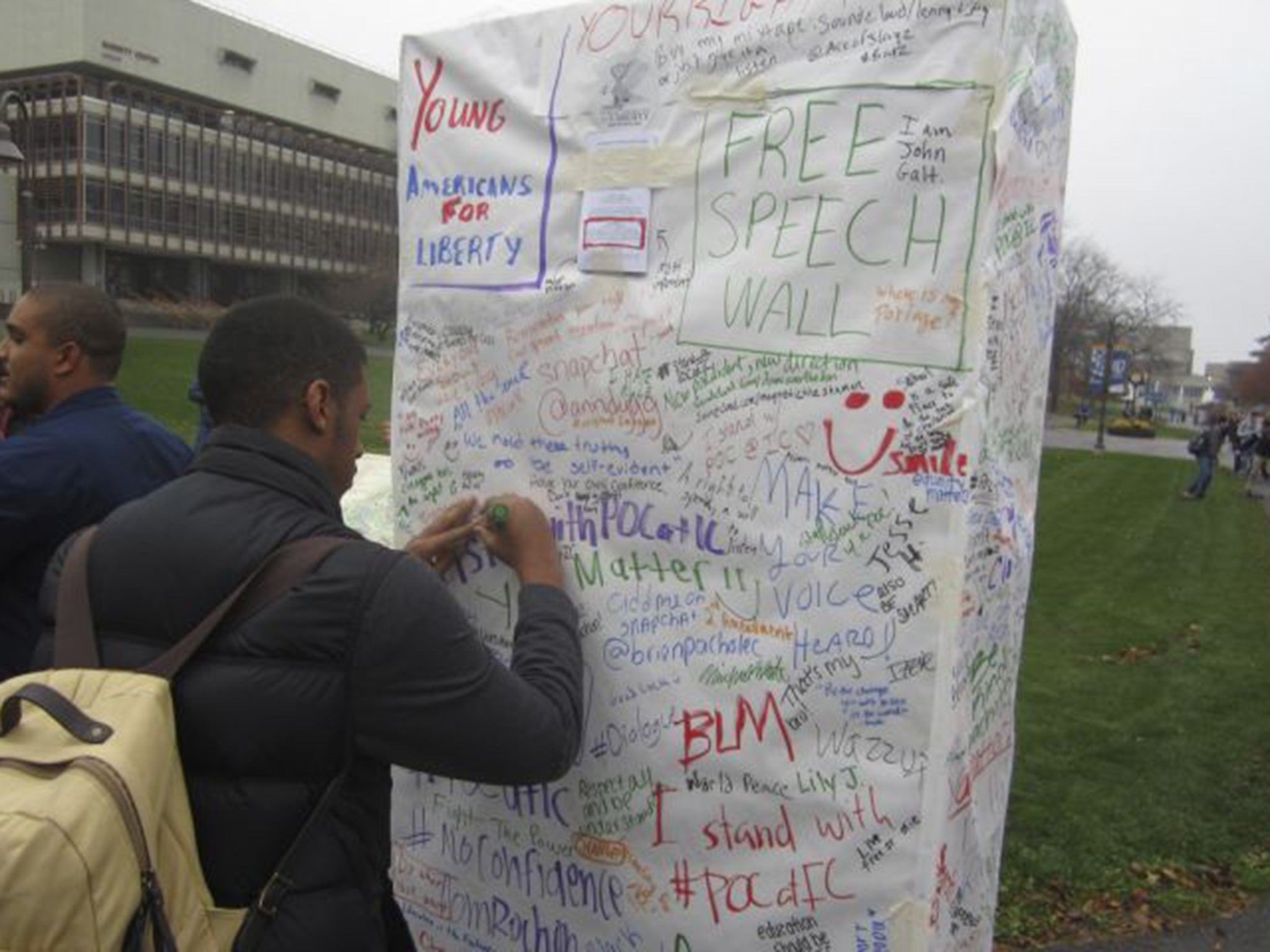 Ithaca College students write messages of protest on the college public free-speech board in Ithaca, New York
