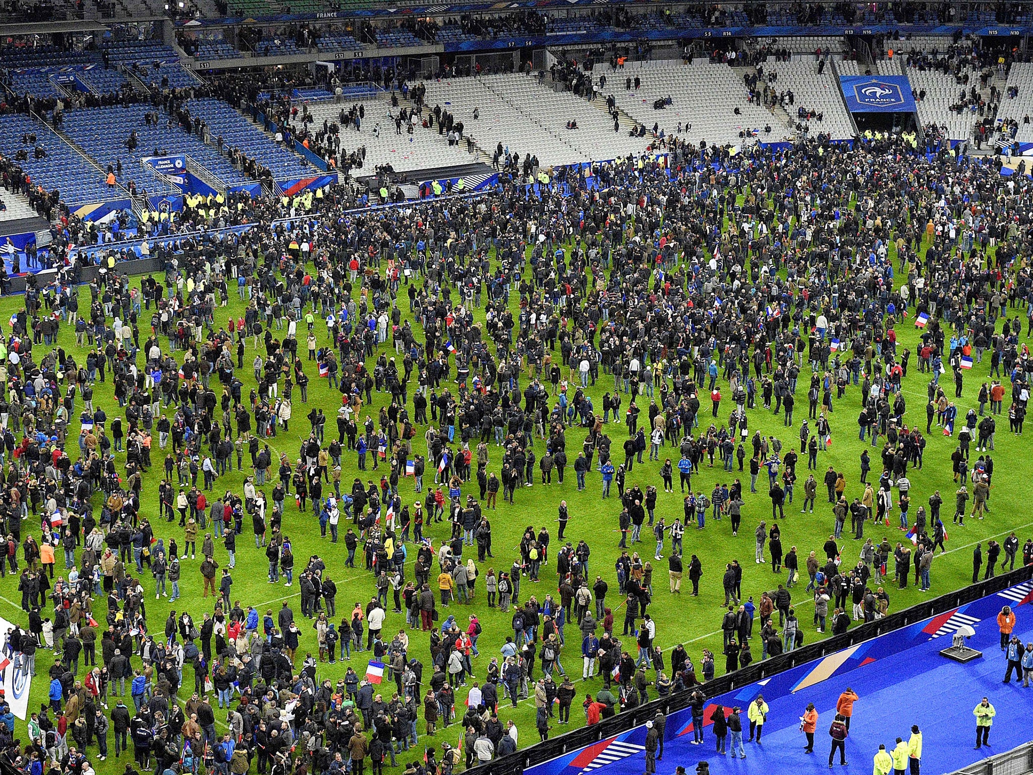 Spectators gather on the Stade de France pitch anxious to discover what had happened outside
