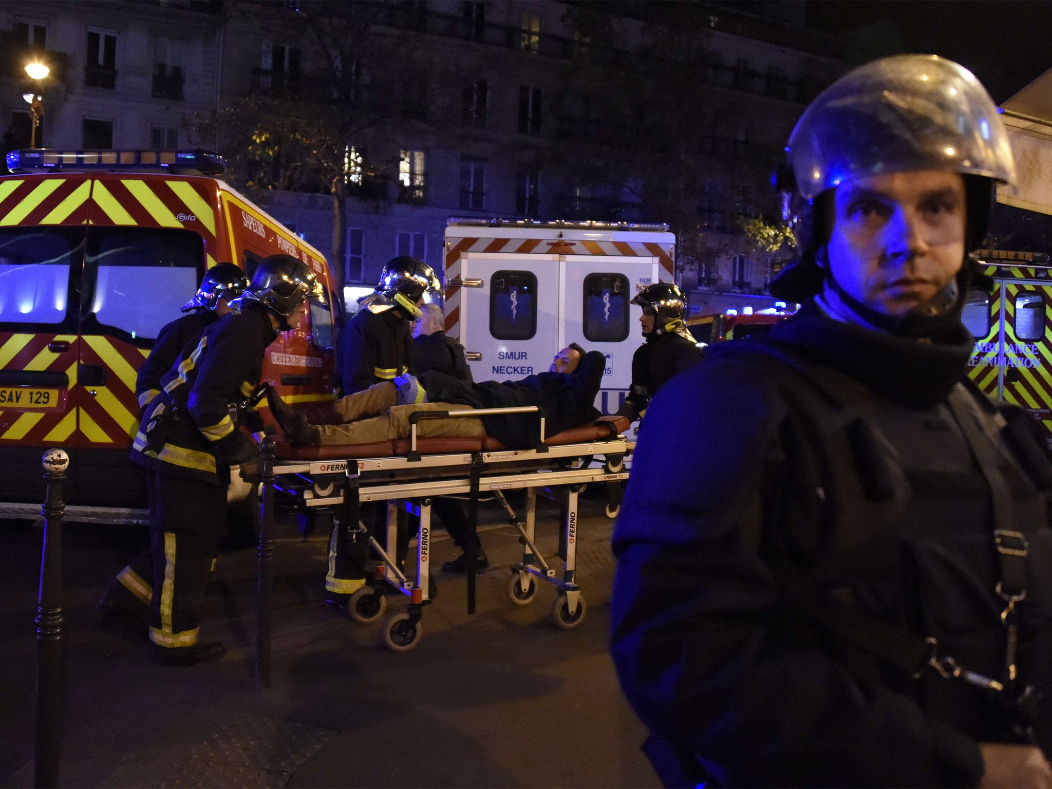 Rescuers workers evacuate a man on a stretcher near the Bataclan concert hall in central Paris