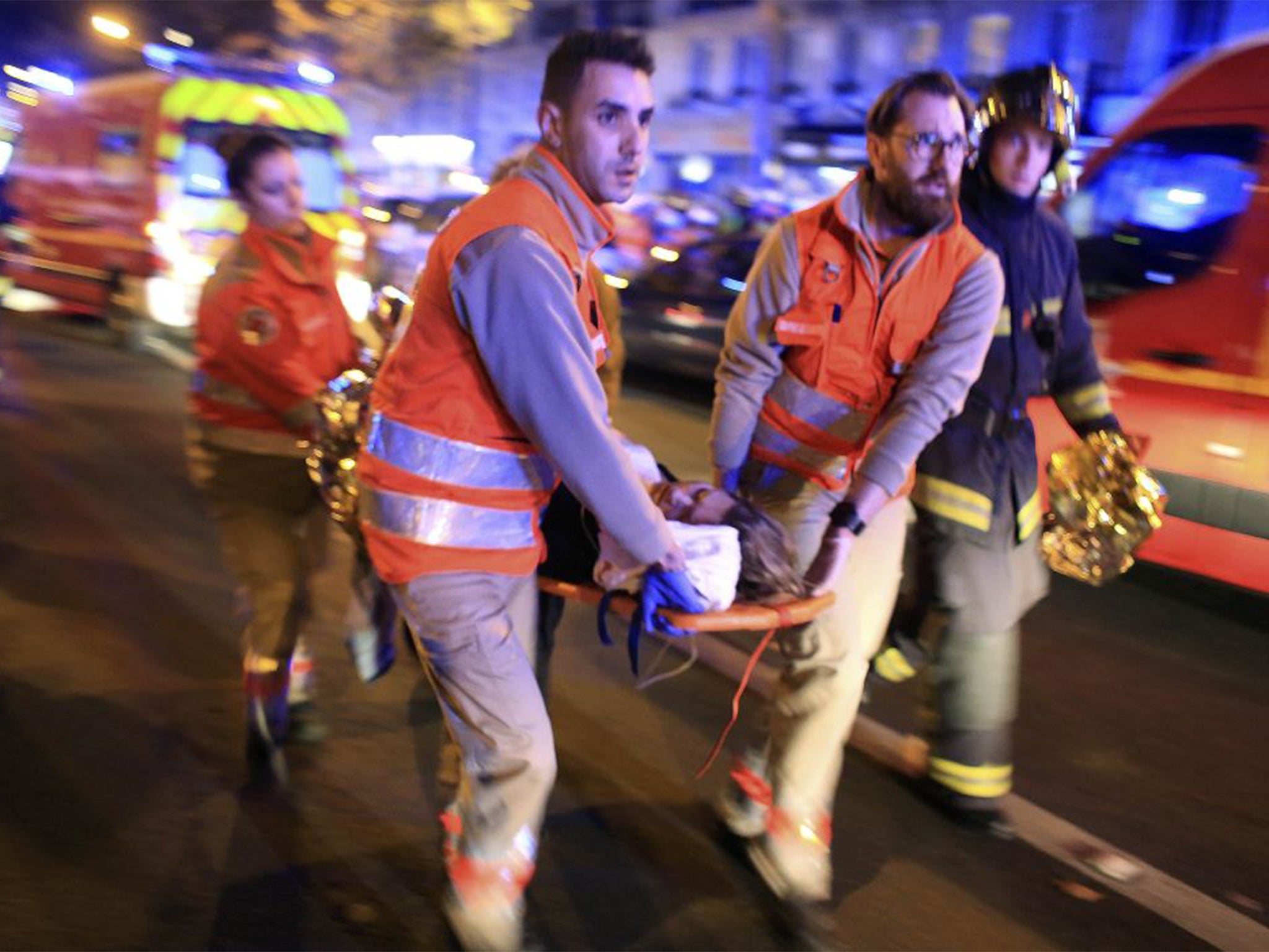 A woman is evacuated from the Bataclan theater after a shooting in Paris