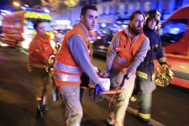 A woman is evacuated from the Bataclan theater after a shooting in Paris