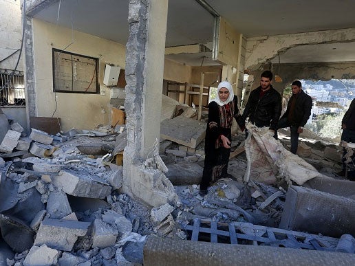 Palestinians look at the rubble of the house of a member of the group accused of killing a couple on October 1, the day after it was destroyed by Israel in the West Bank city of Nablus on November 14
