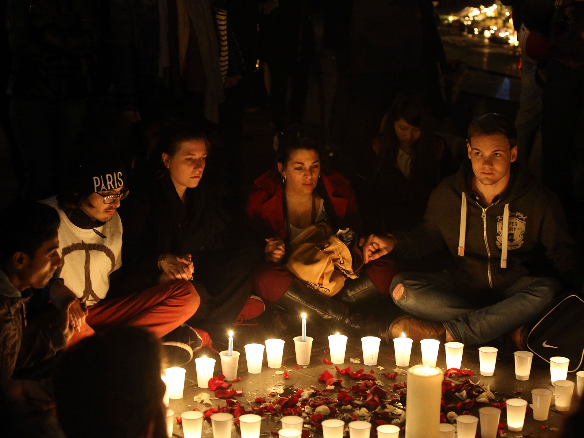 Crowds gather to look at floral tributes and candles left at Place de la Republique (Republic Square), following the terrorist attacks