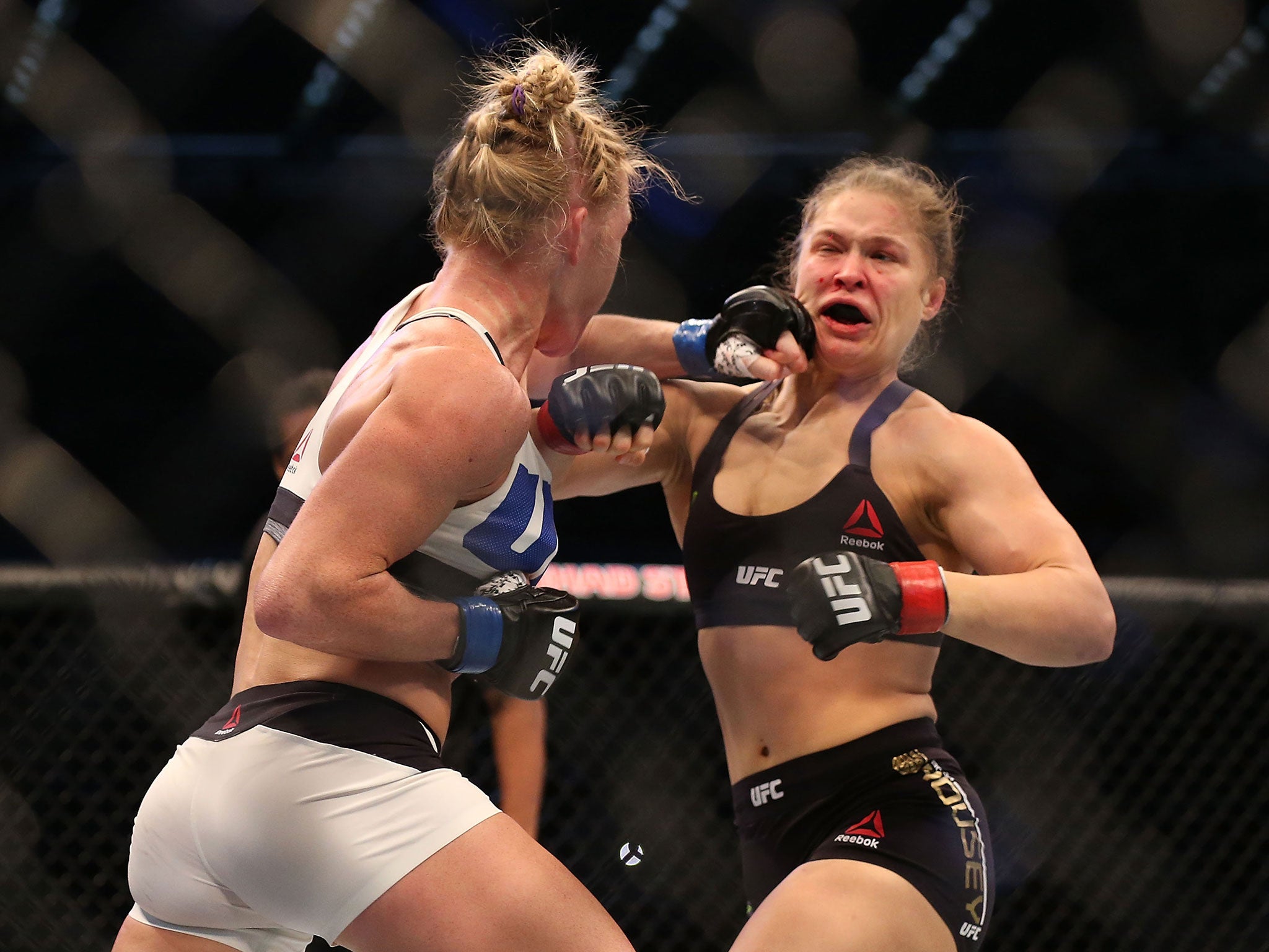 Holly Holm (left) lands a blow on Ronda Rousey