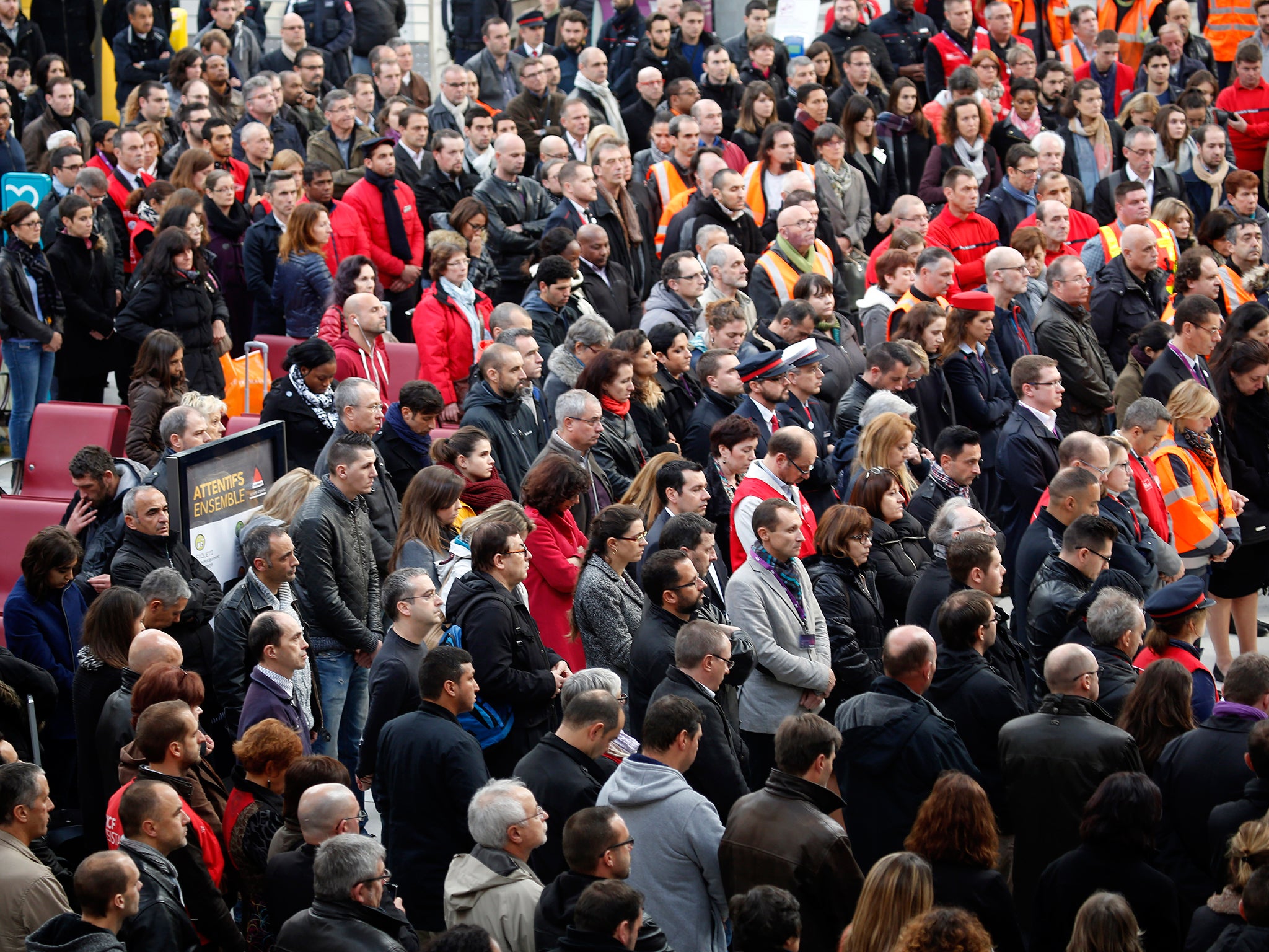 People stand for a minute of silence at the Gare de Lyon train station in Paris