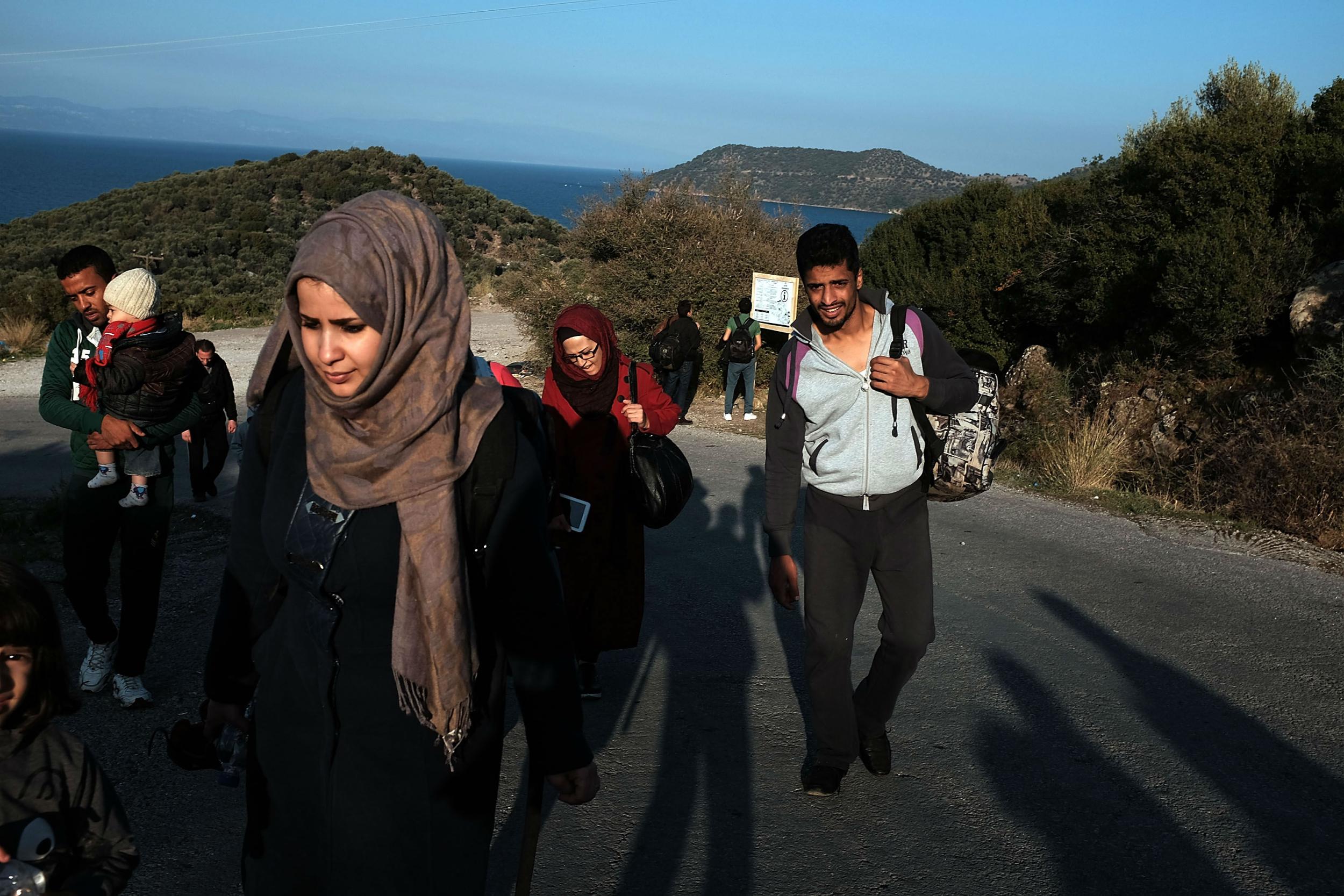 A group of migrants walks to a refugee reception centre after arriving by raft from Turkey onto the island of Lesbos