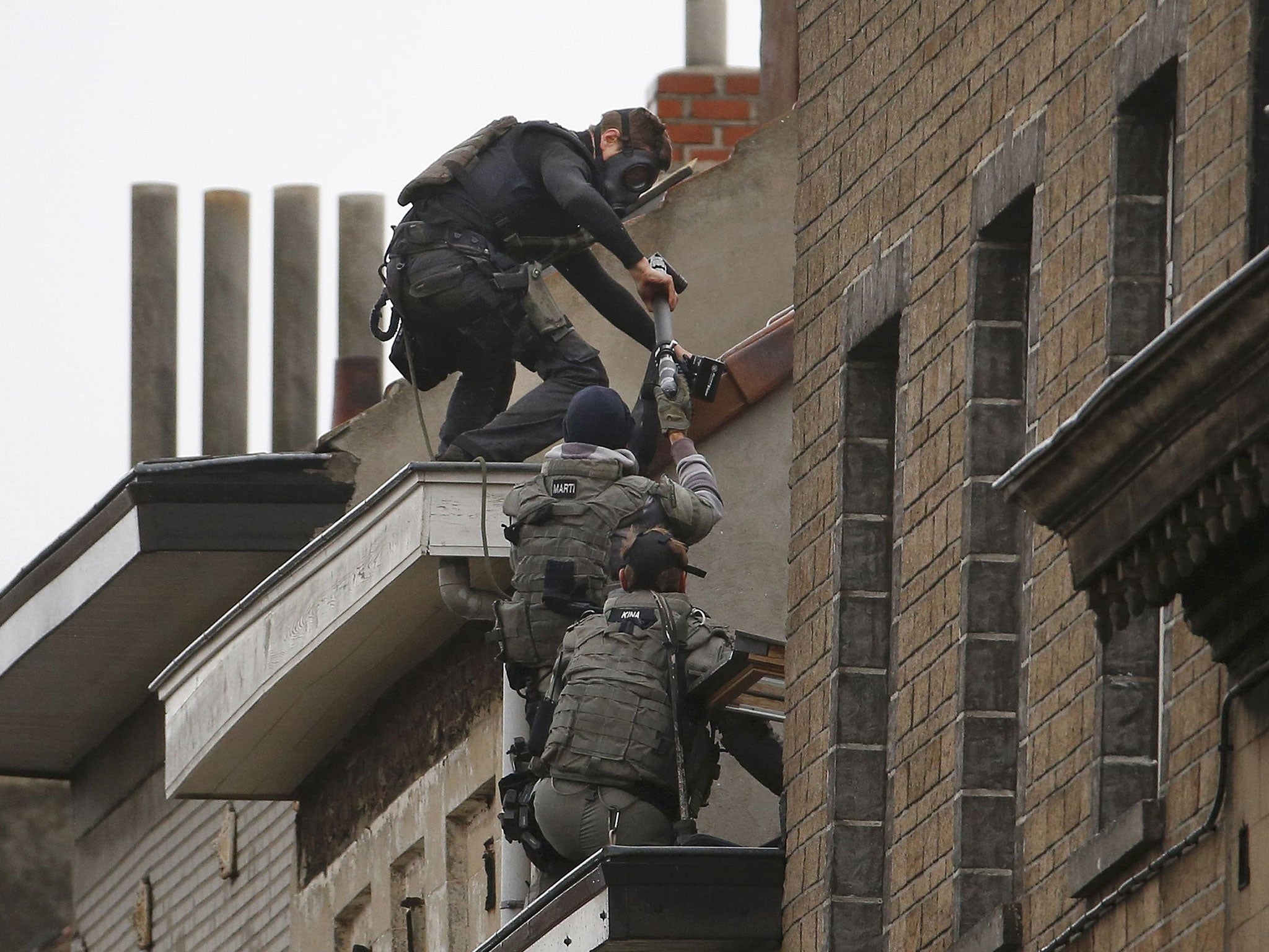 Belgian special forces police climb high on an apartment block during a raid in the Brussels suburb of Molenbeek, 16 November