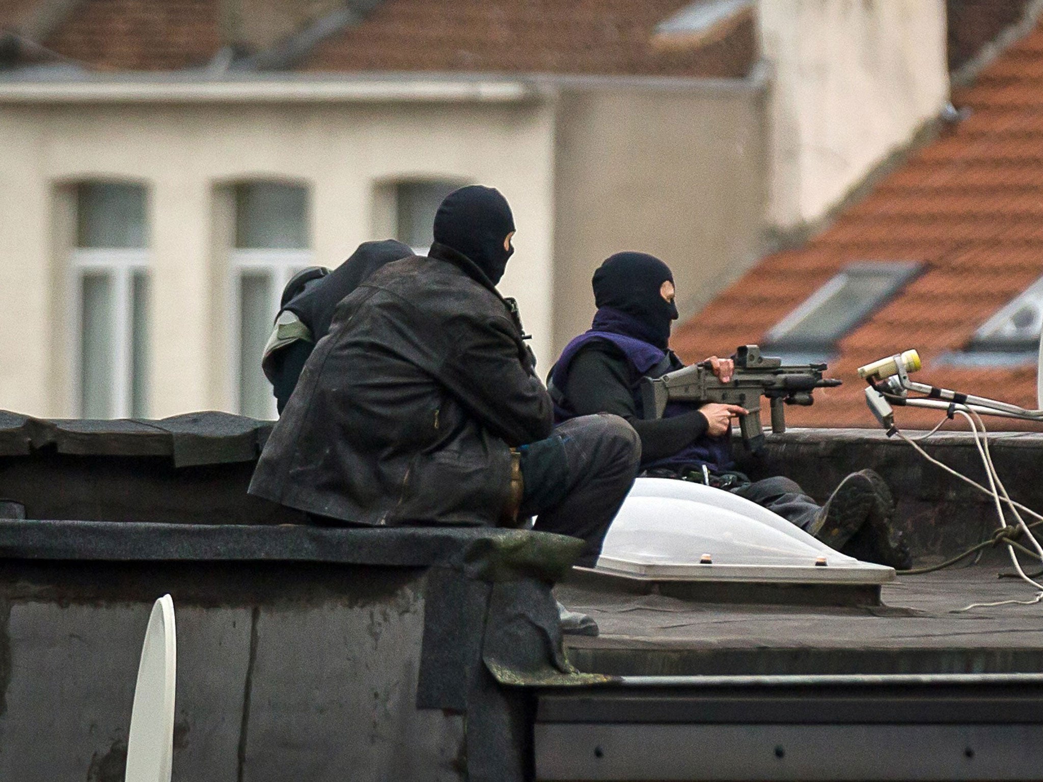 Special force officers stand guard on a roof in Rue Delaunoy, in the district of Molenbeek-Saint-Jean in Brussels on November 16, 2015.