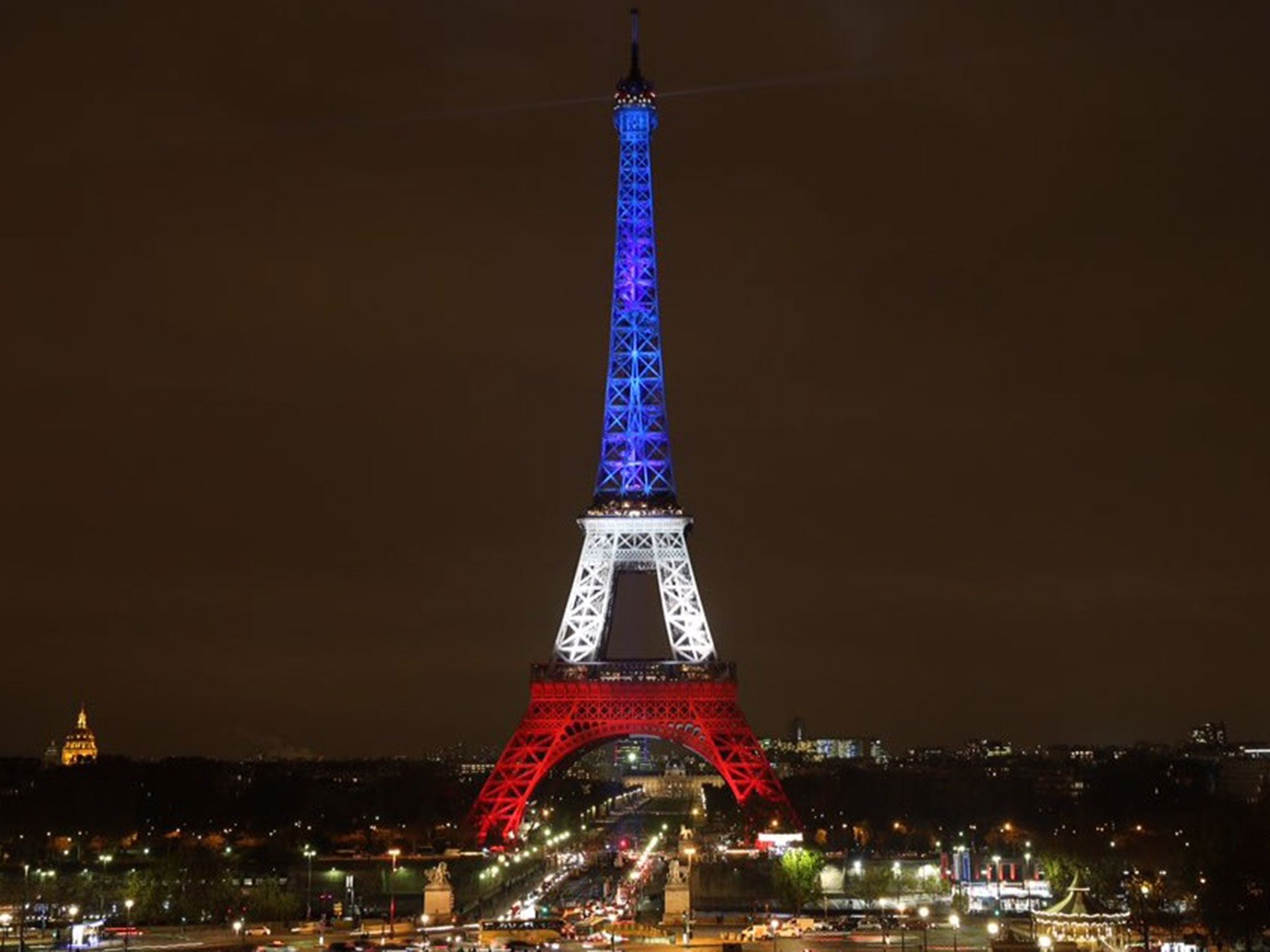 The Eiffel Tower displays the colours of the French Tricolour after being dimmed since Friday