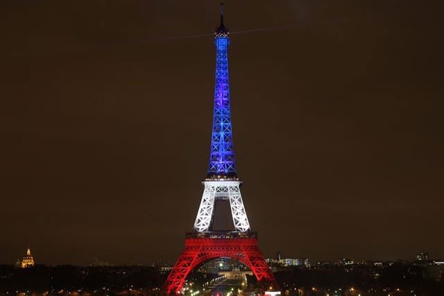 The Eiffel Tower displays the colours of the French Tricolour after being dimmed since Friday