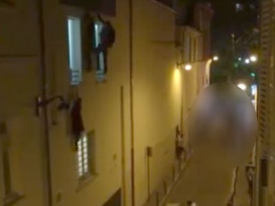 The video shows the woman hanging from a window ledge at the Bataclan theatre