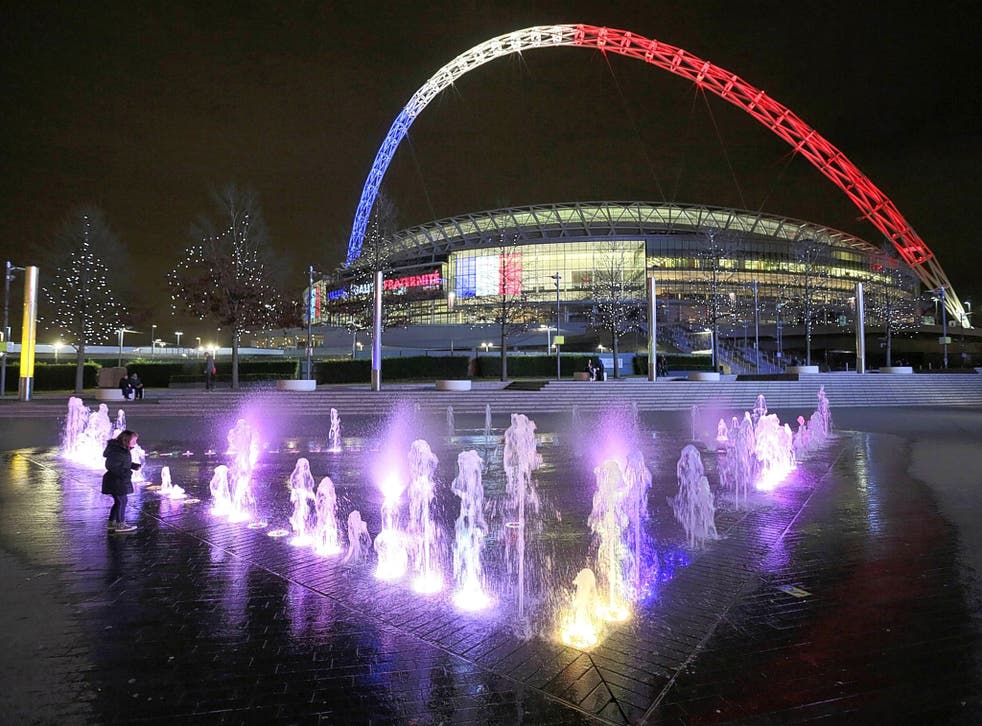 The arch at Wembley Stadium is lit in the colours of the Tricolore