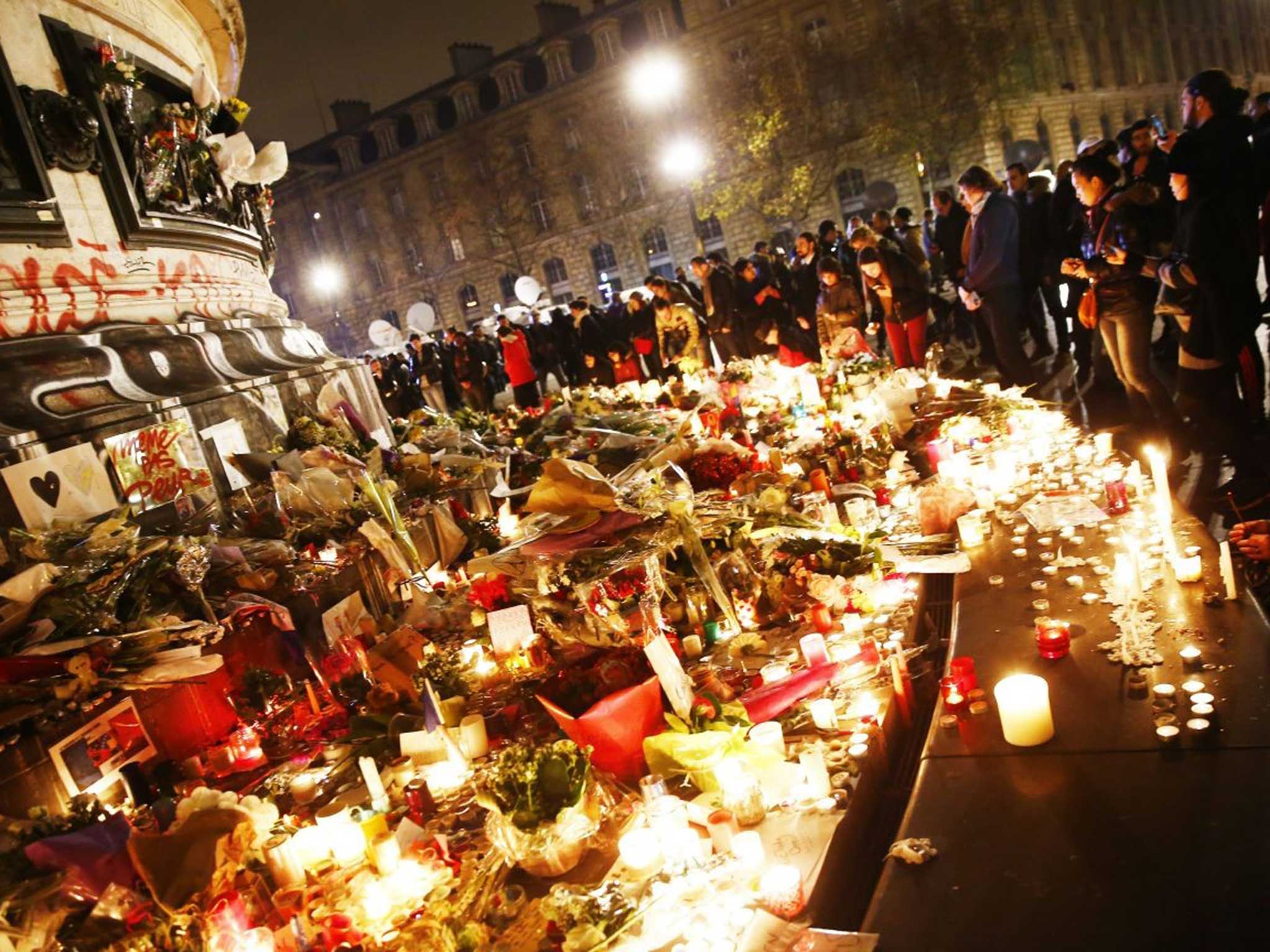 People honouring the victims at Place de la Republique with flowers and candles