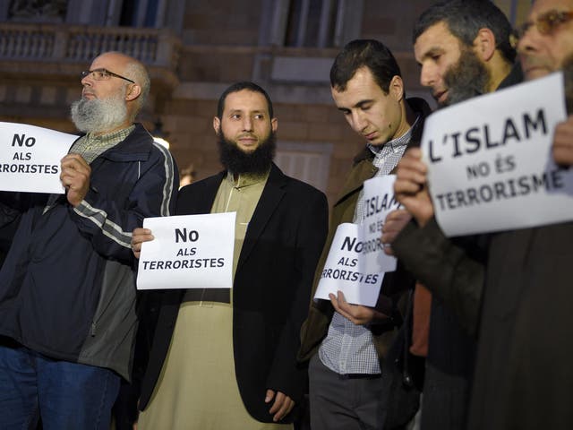 People show posters reading 'No to terrorists' and 'Islam is not terrorism' during a demonstration, called by the IBN Battuta Foundation on behalf of the Muslim community