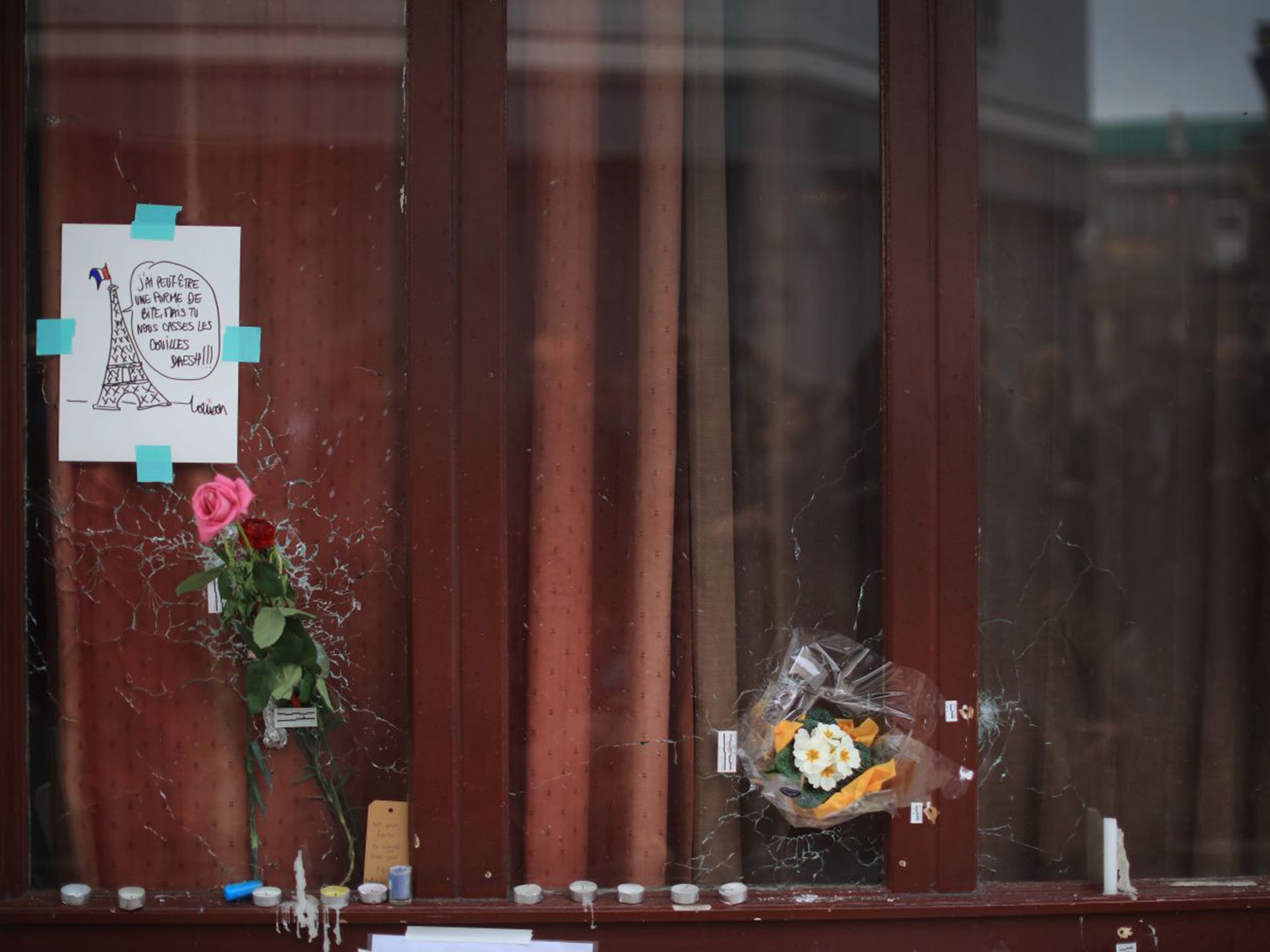 Flowers and tributes adorn the bullet damaged windows of the Le Carillon restaurant, one of the scenes of the November 16 attacks in Paris