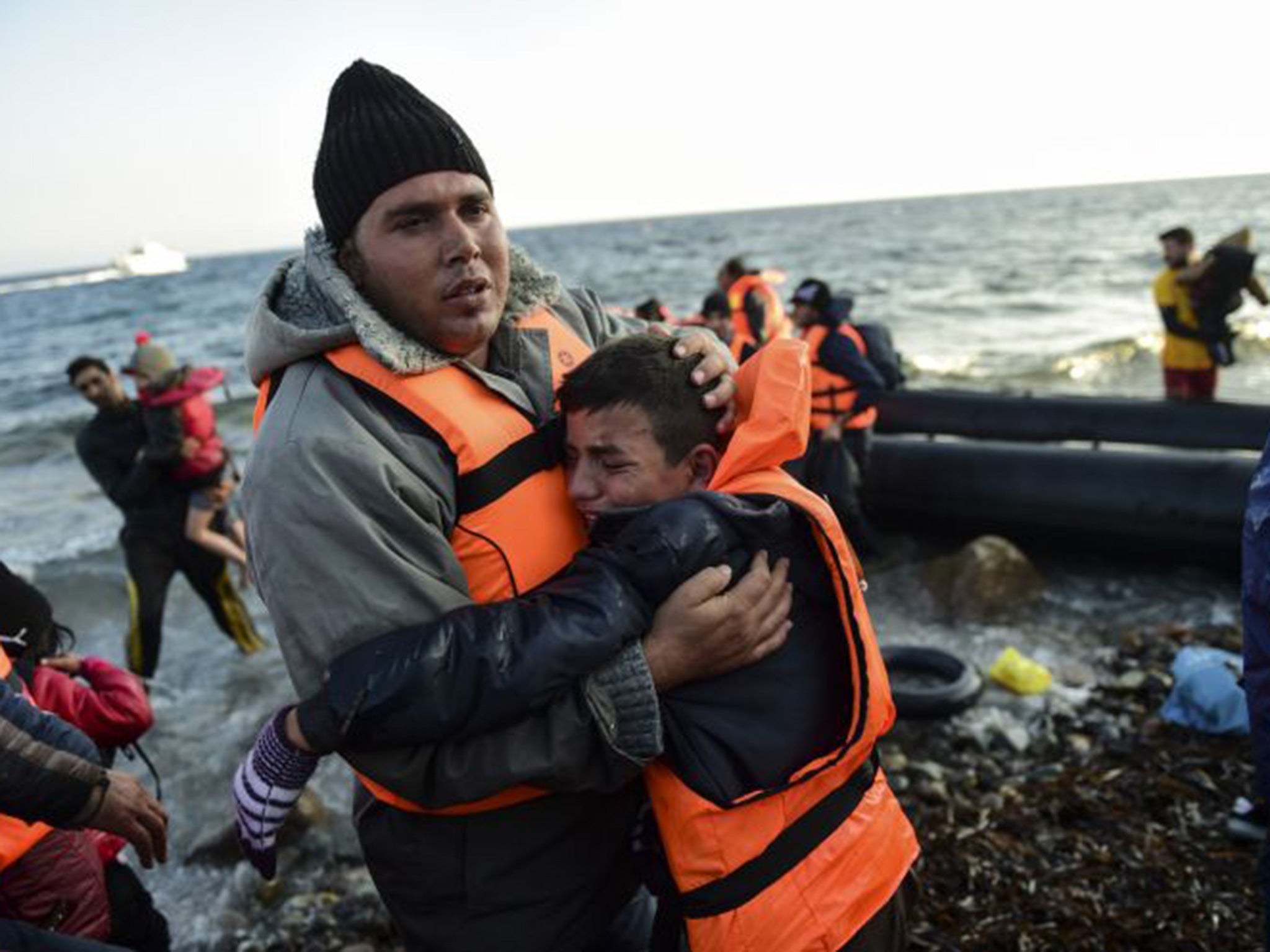 Refugees alight on the island of Lesbos after crossing the Aegean Sea from Turkey