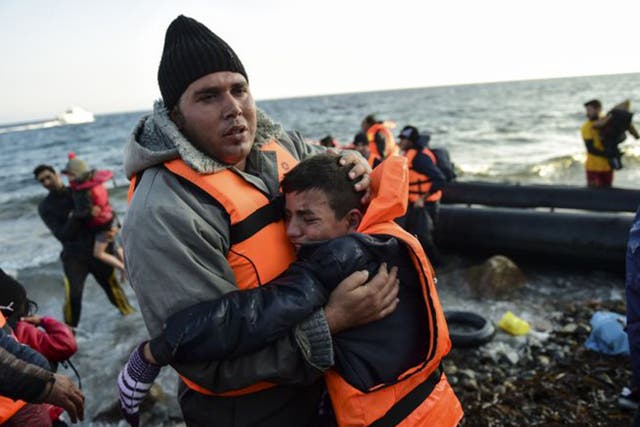 Refugees alight on the island of Lesbos after crossing the Aegean Sea from Turkey