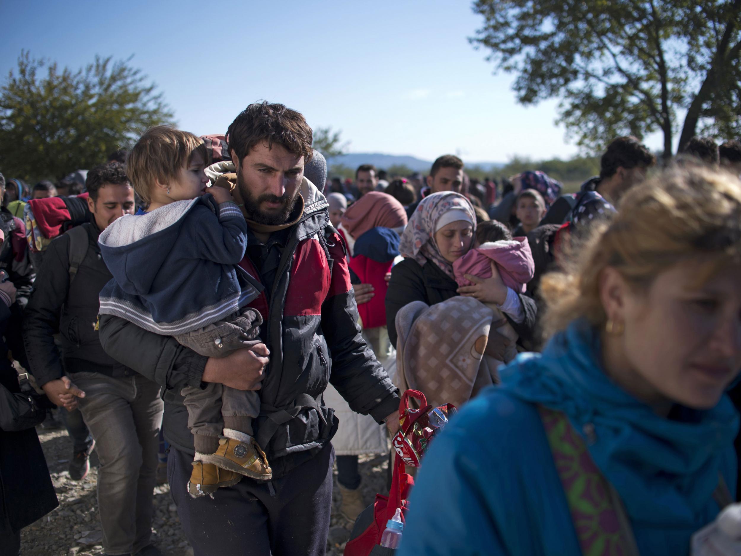 Migrants and refugees enter a registration camp after crossing the Greece-Macedona border