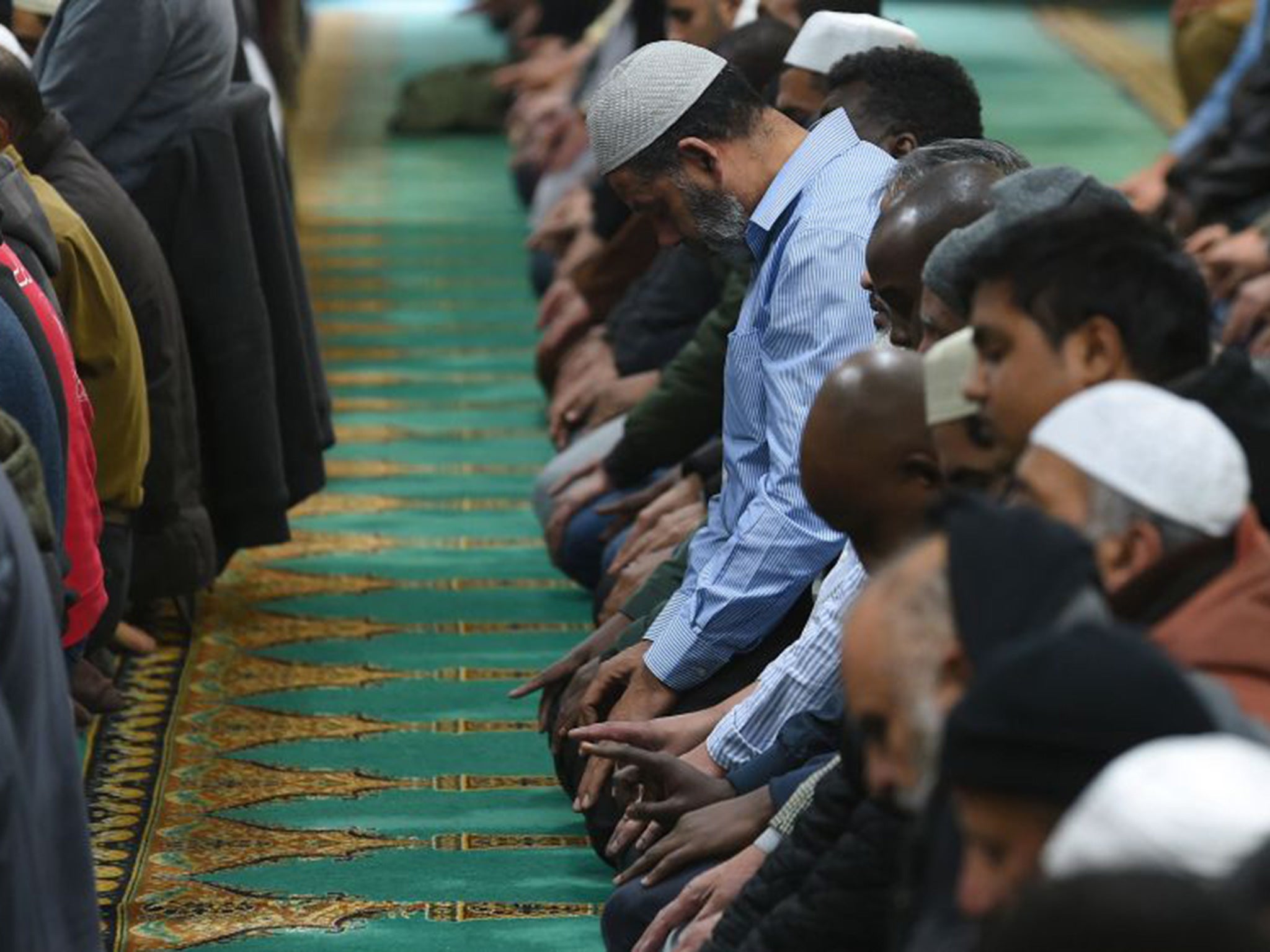 Muslim men observe a minute's silence after their prayers inside Birmingham Central Mosque to remember the victims of Friday's attacks in Paris