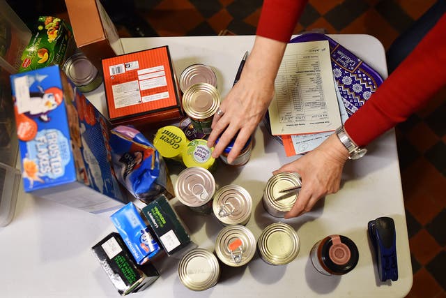 A volunteer selects food for a visitor’s order at a food bank charity in west London