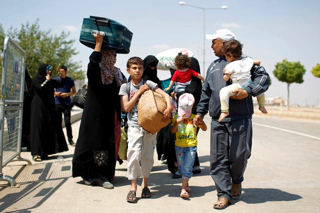 People walk with their belongings to the Syrian border town of Tal Abyad.