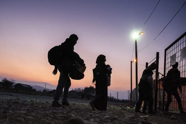 Migrants and refugees enter a registration camp