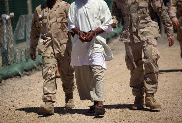 US Navy guards escort a detainee at Guantanamo Bay.