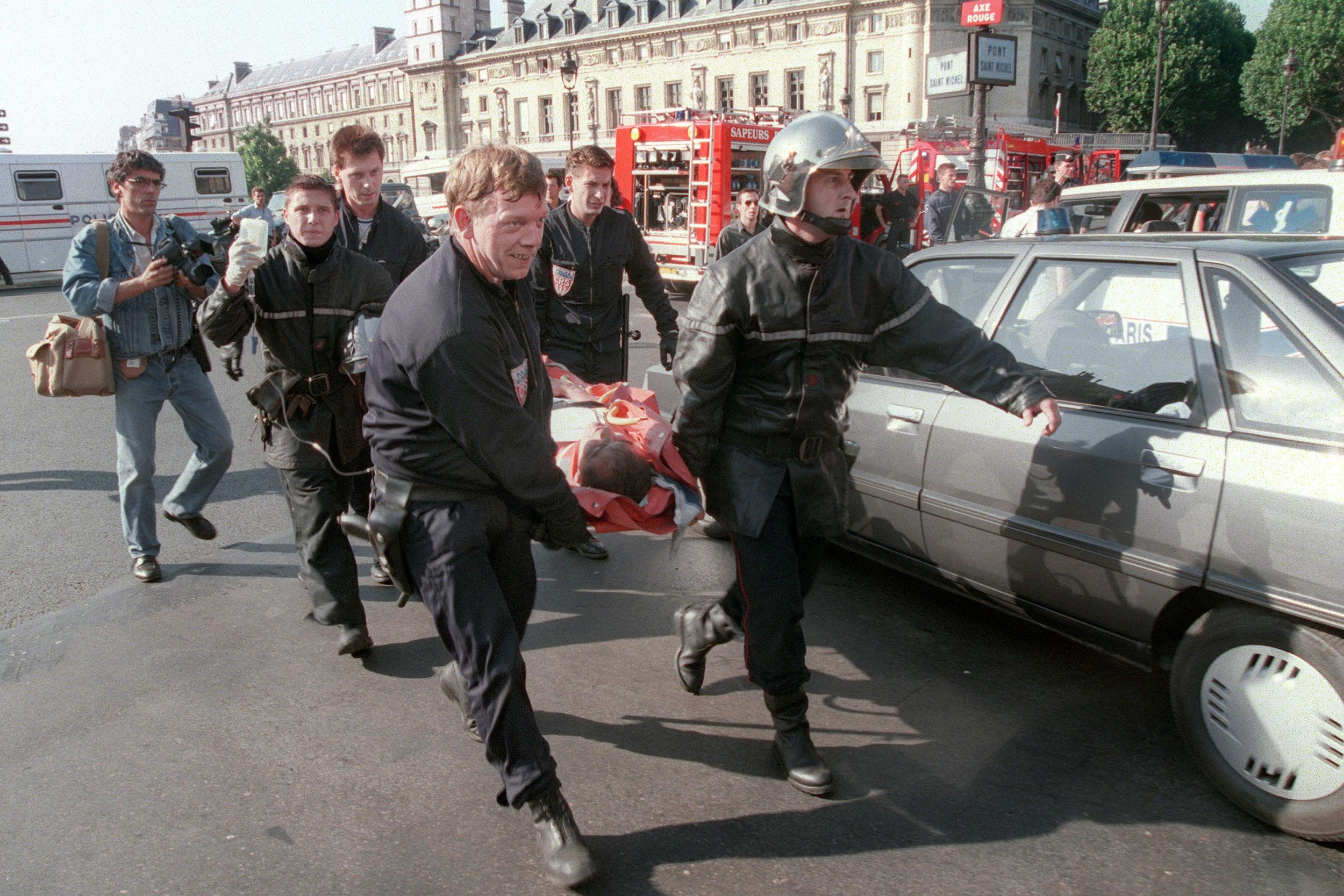 Firemen carry a victim of an Islamist bombing at Saint-Michel station in Paris in 1995 AFP/Getty