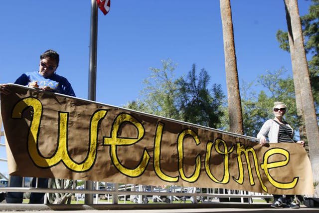 Supporters place a sign welcoming Syrian refugees is placed at the entrance to the office of Arizona's governor