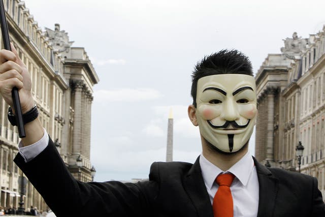 A protester wearing an Anonymous Guy Fawkes mask takes part in a demonstration in front of the Concorde square in Paris, as part of a 'popular march' gathering Anonymous and Indignant protesters, to denounce an 'electoral farce', on April 21, 2012, on the eve of the first-round poll of French presidential election