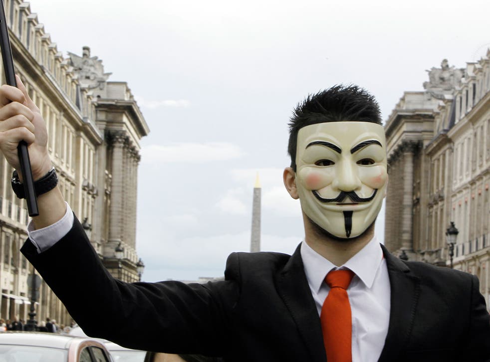 A protester wearing an Anonymous Guy Fawkes mask takes part in a demonstration in front of the Concorde square in Paris, as part of a 'popular march' gathering Anonymous and Indignant protesters, to denounce an 'electoral farce', on April 21, 2012, on the eve of the first-round poll of French presidential election