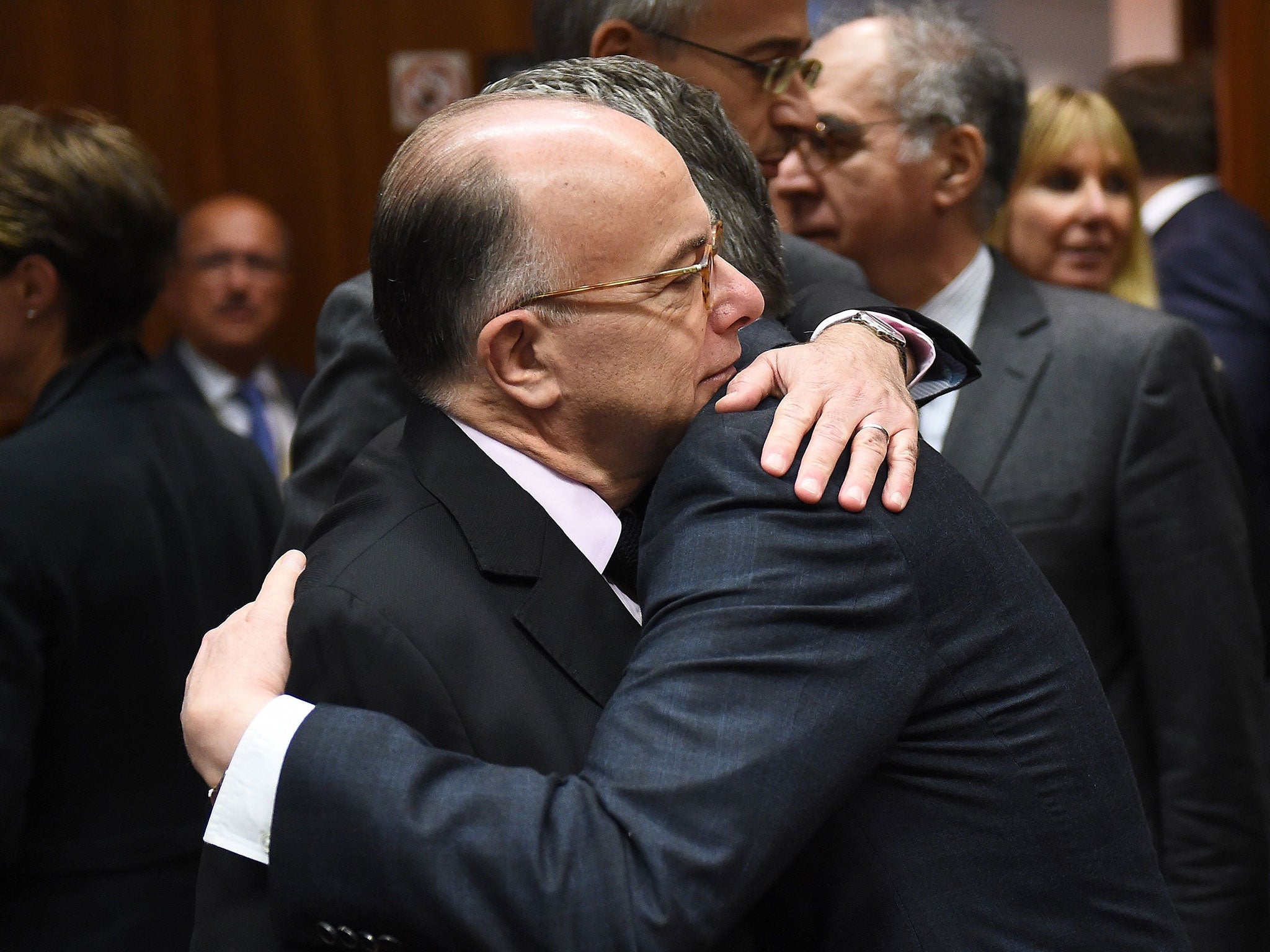 German Interior Minister Thomas de Maiziere (R) embraces French Interior Minister Bernard Cazeneuve during a meeting at the European Council in Brussels on 20 November