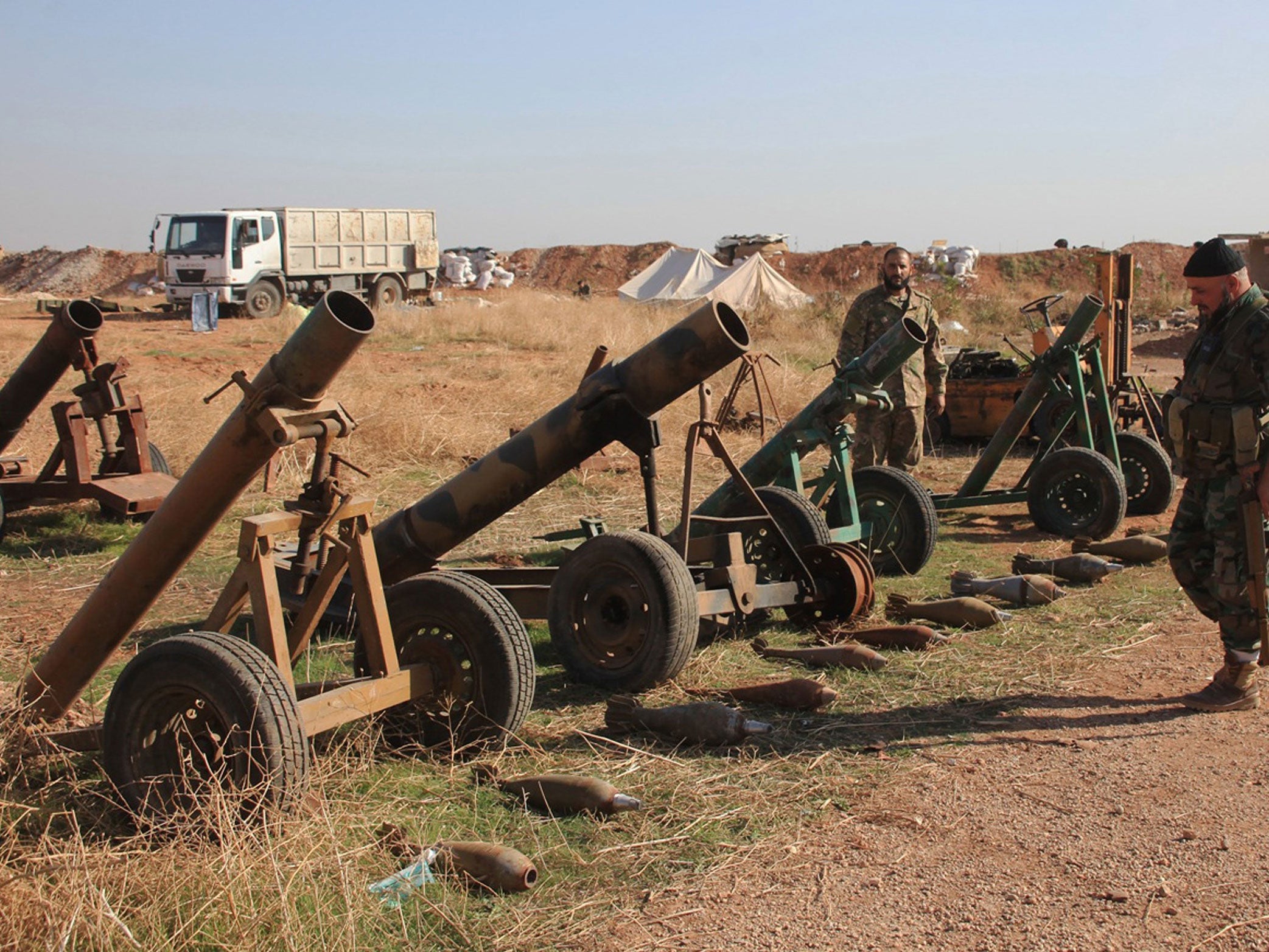 Syrian pro-government forces inspect weapons reportedly left by Islamic State (IS) group fighters