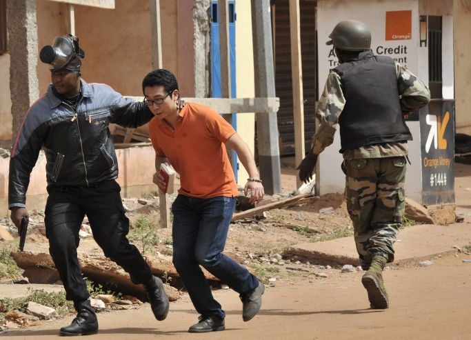 Malian security forces evacuate a man