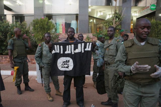 Malian security officials show a jihadist flag they said belonged to attackers in front of the Radisson hotel in Bamako
