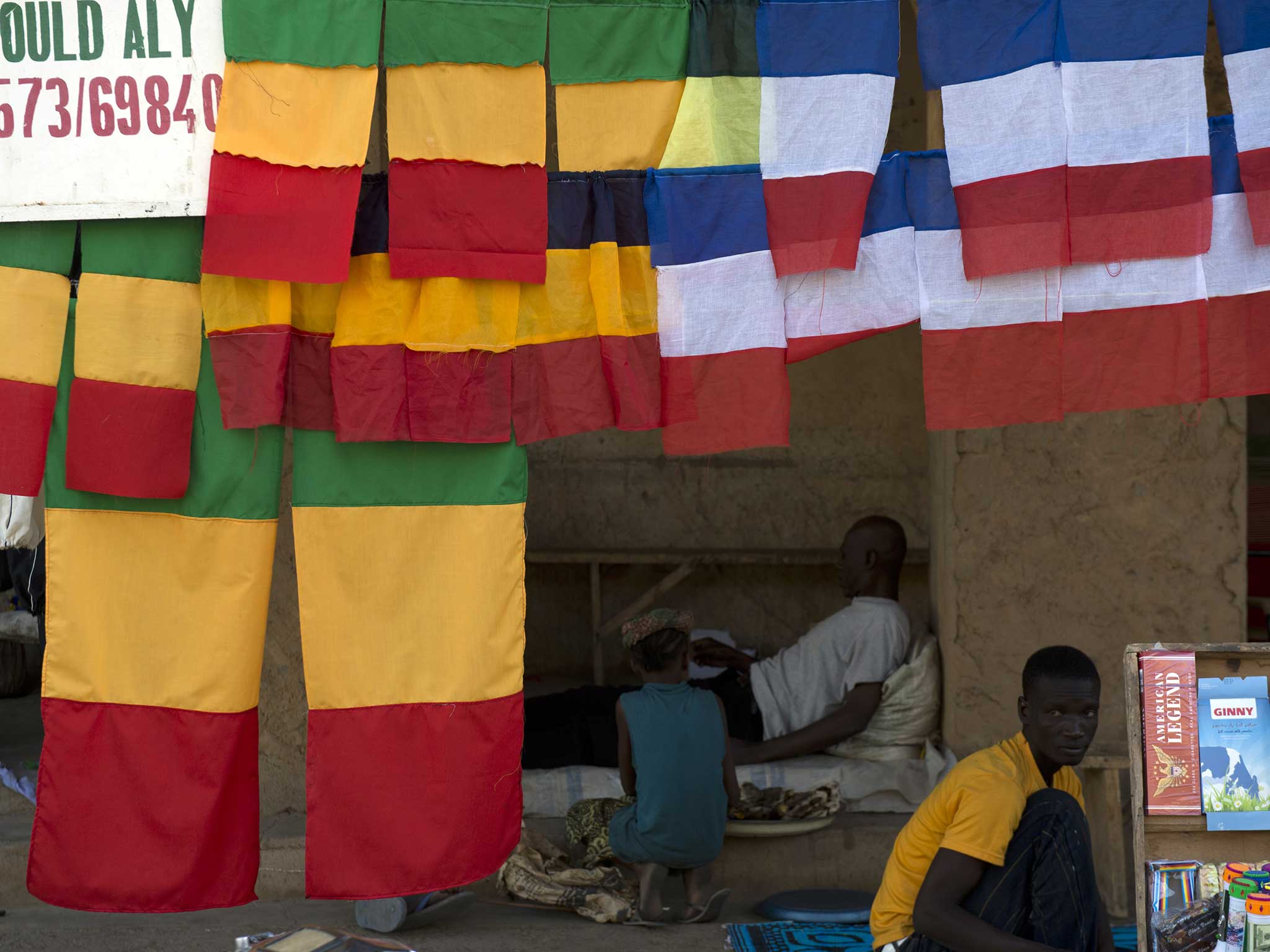 French and Malian flags fly in a marketplace in a northern Malian town