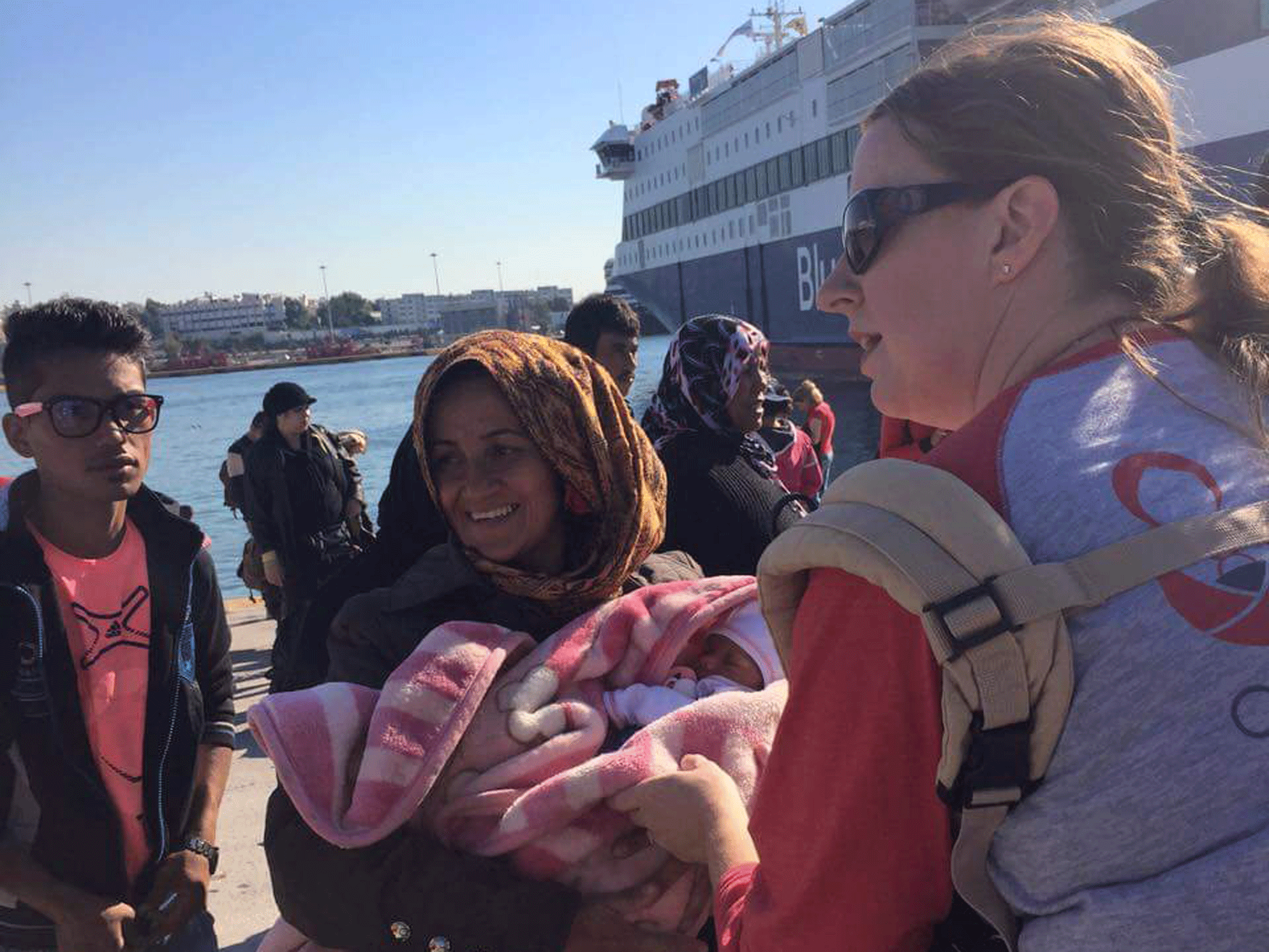 Volunteers are handing out baby carriers at refugee camps in Greece