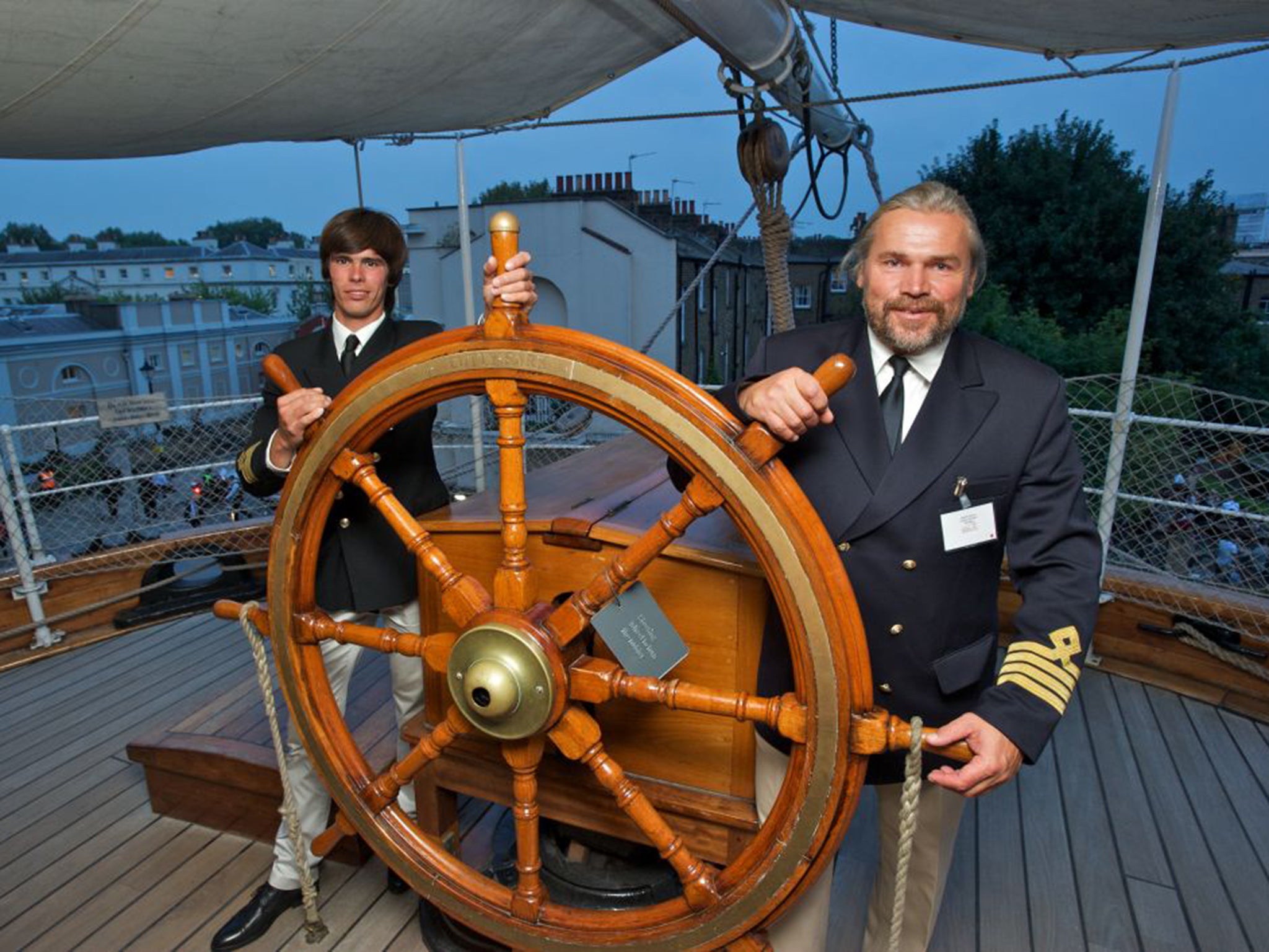 Vladimir Martus, right, at the wheel of the restored Cutty Sark in Greenwich, London