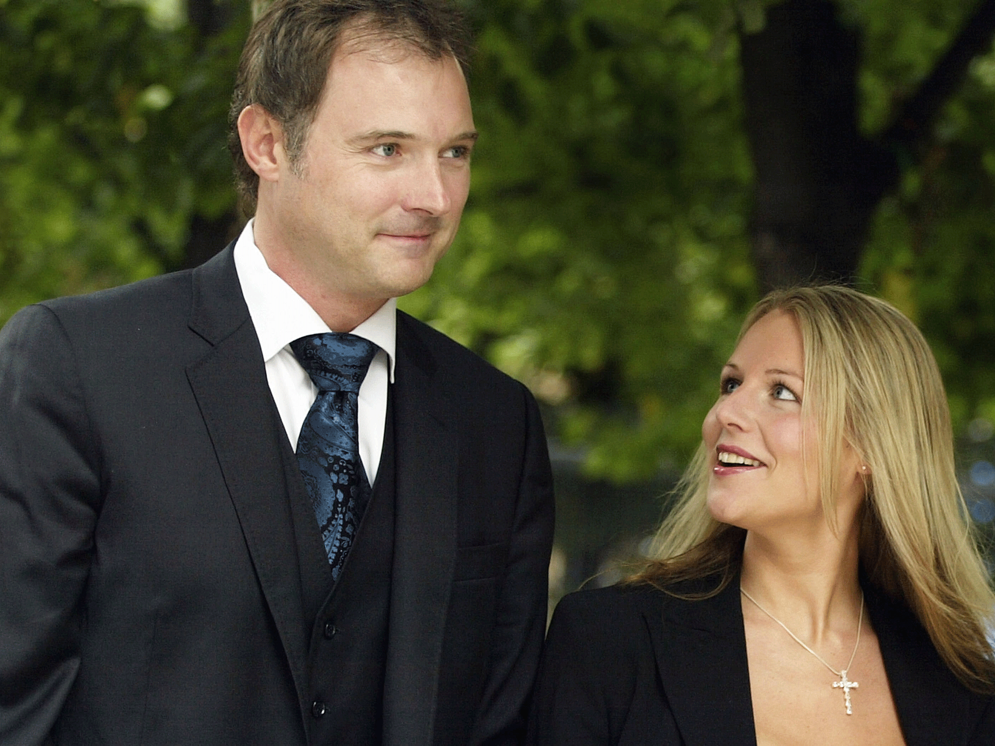 Former television presenter John Leslie (R) speaks to the media after leaving Southwark Crown Court watched by girlfriend Abby Titmuss and two british police officers July 31, 2003 in London, England.
