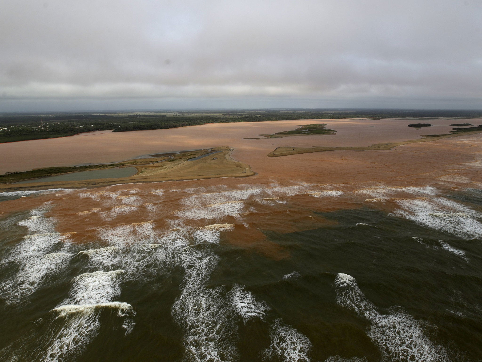 The mouth of the Doce River, flooded with mud after a dam owned by mining firms burst; the disaster has displaced hundreds of people and may affect fish, sea turtles and a coral reef
