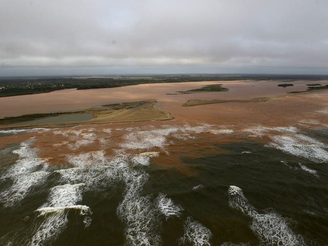 The mouth of the Doce River, flooded with mud after a dam owned by mining firms burst; the disaster has displaced hundreds of people and may affect fish, sea turtles and a coral reef