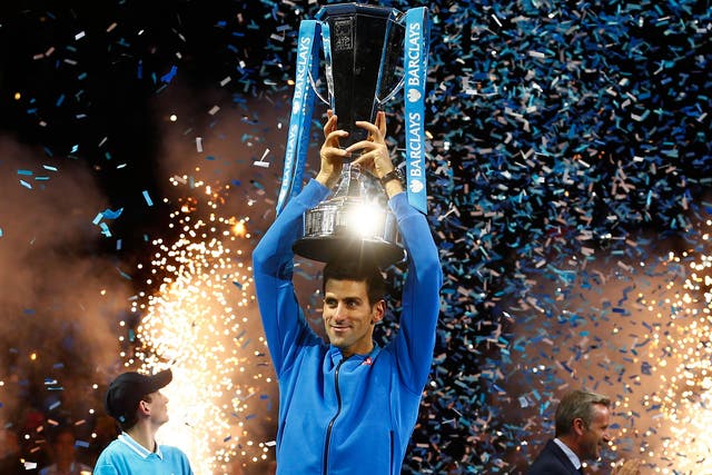 Novak Djokovic celebrates with his World Tour Finals trophy