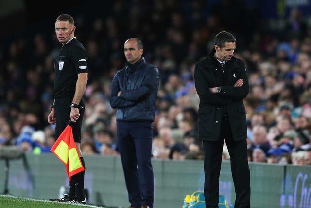 Remi Garde (R) can't look on during the match against Everton