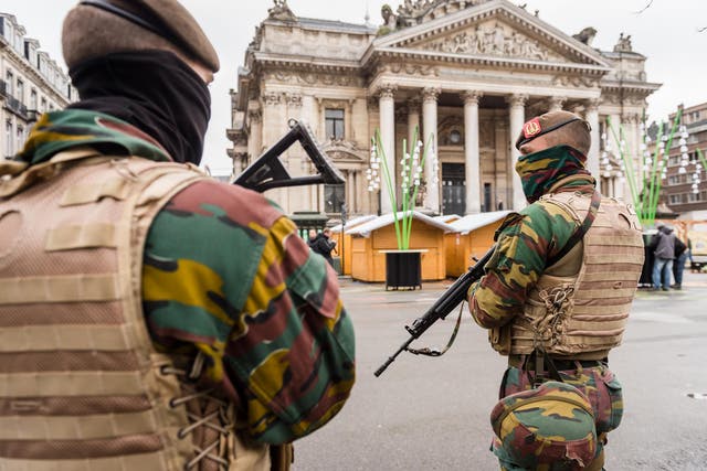 Belgian Army soldiers patrol near Christmas huts in front of the old Brussels' stock exchange