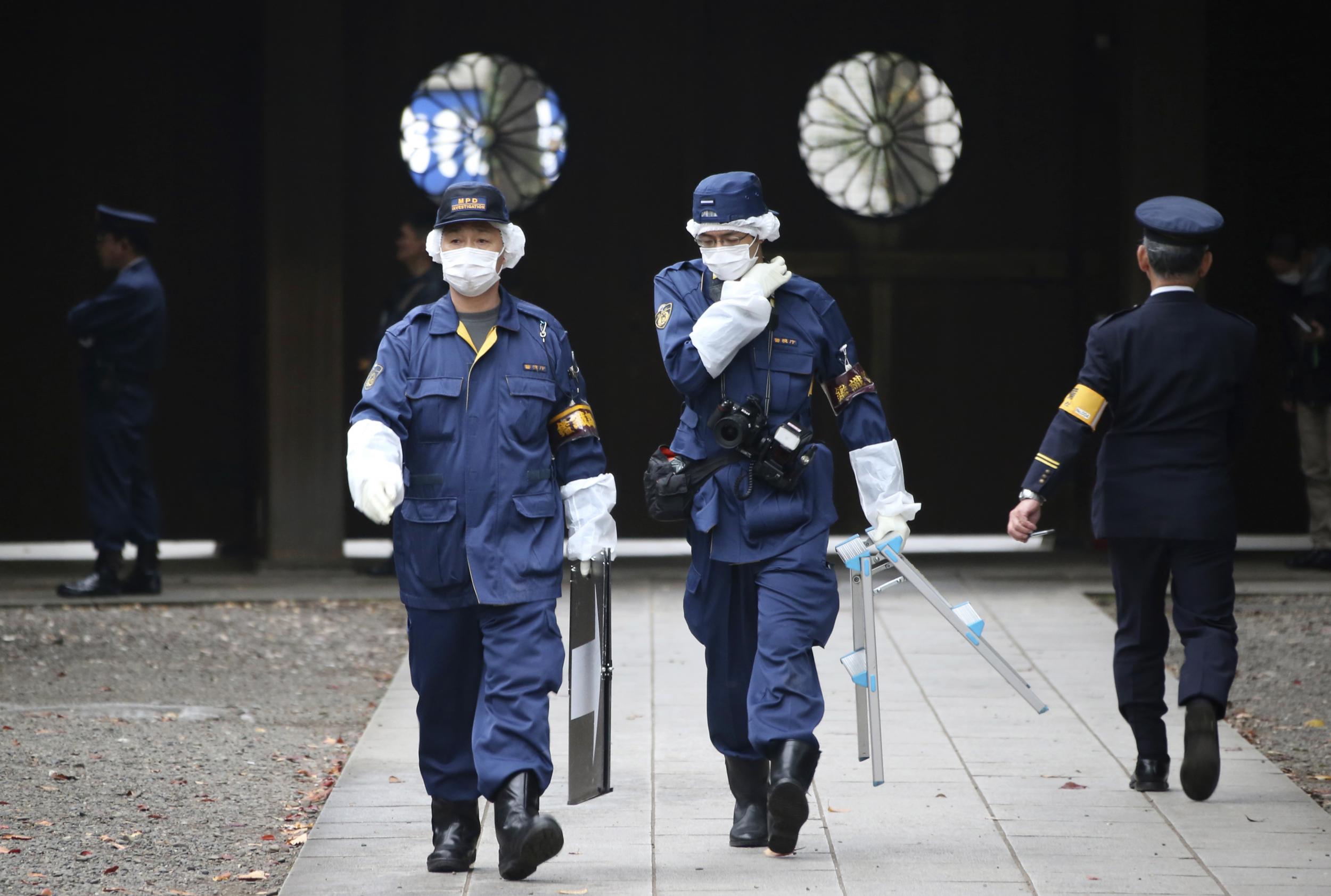 Police officers investigate the compound of the Yasukuni shrine